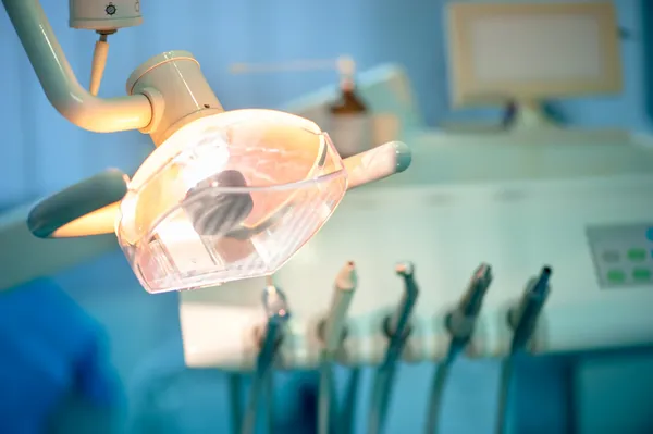 Close-up of dentist light on special chair and different tools in background — Stock Photo, Image