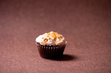 izole kahverengi zemin üzerine fındık kremalı tepesi ile çikolatalı kek