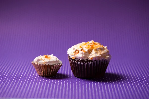 Pastelitos de terciopelo de chocolate con cobertura de helado de vainilla aislado sobre fondo púrpura —  Fotos de Stock