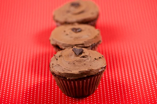 Nahaufnahme von Schokoladenmuffin vor rotem Tupfen-Hintergrund — Stockfoto