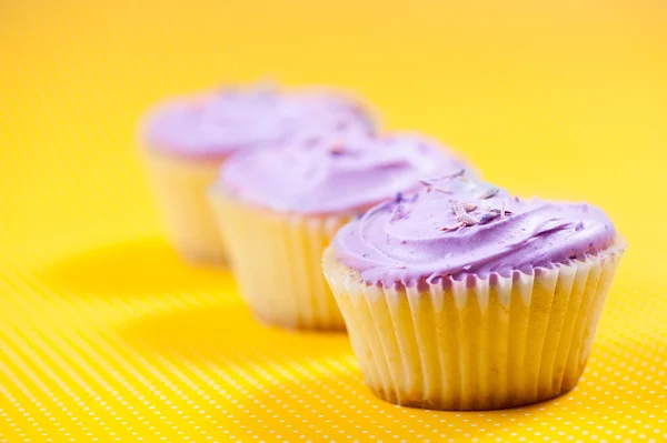 Raspberry muffin with vanilla filling against yellow background — Stock Photo, Image