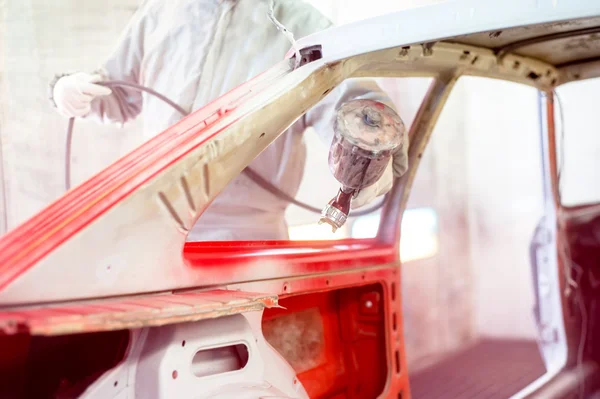 Professionele werktuigbouwkundig ingenieur in de auto-industrie werken en een rode auto schilderen — Stockfoto