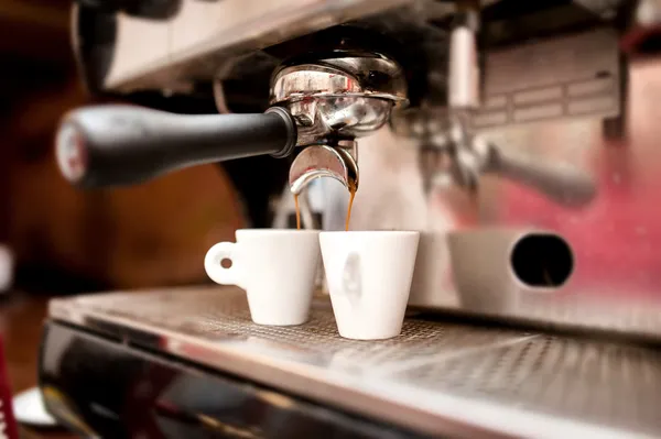 Эспрессо-машина наливает кофе в чашки — стоковое фото