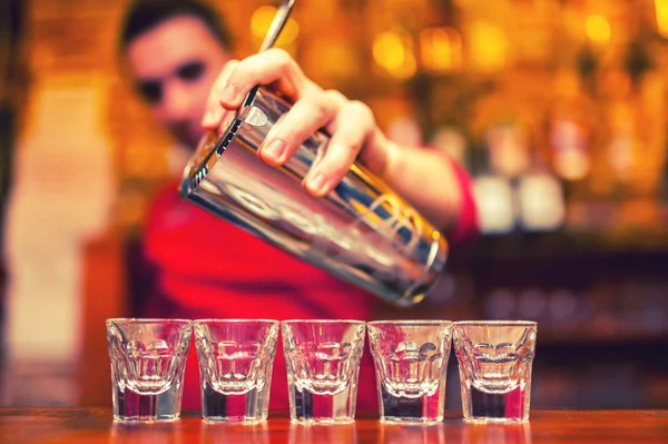 Detail barman ruku nalil alkoholický nápoj do sklenic — Stock fotografie
