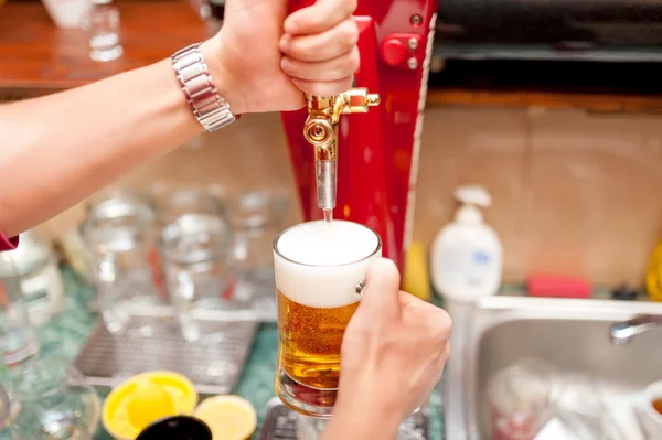 Bartender brewing draft beer in pub — Stock Photo, Image