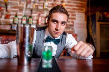Barmen portresi arkasında bar kokteyl araçları ve içecekler üzerinde bar