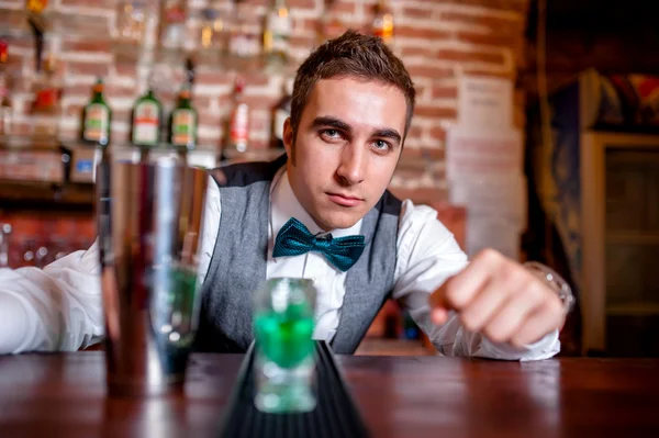 Portrait of barman behind bar with cocktail tools and drinks on bar — Zdjęcie stockowe