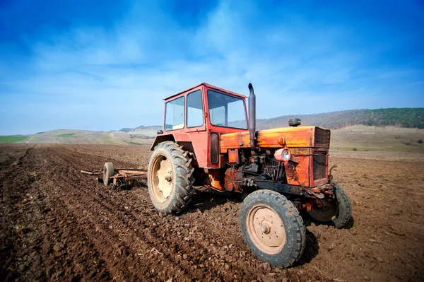 Agricultor que trabalha os campos com trator e arado — Fotografia de Stock