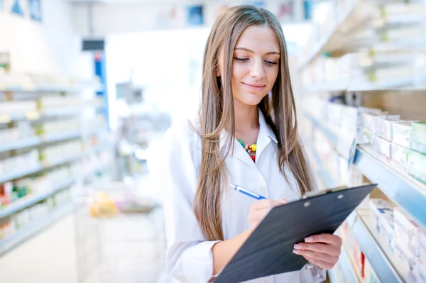 Portrait of blonde pharmacist or health care worker with clipboard — Stockfoto