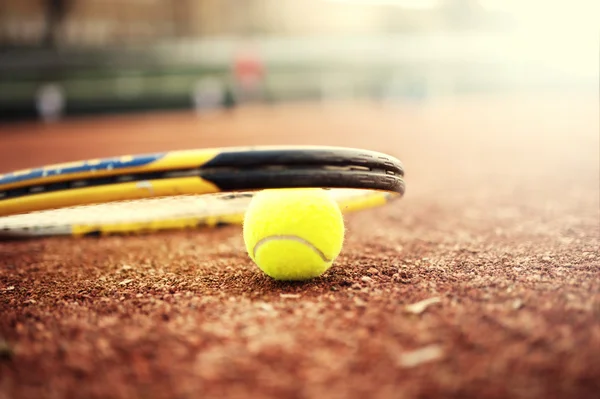 Close-Up tenis top ve raket toprak kortta yaz gününde — Stok fotoğraf
