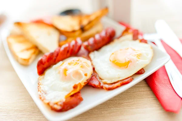 Close-up of healthy breakfast with fried eggs, bacon, sausages, toast bread and mushrooms — Stock Photo, Image