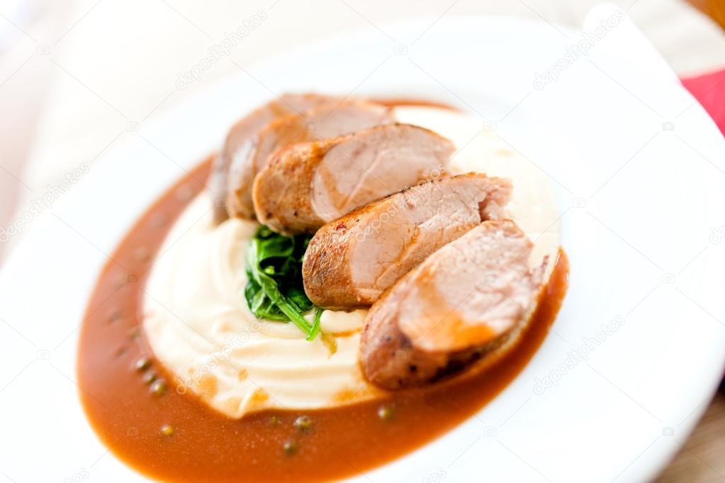 Mashed potatoes with grilled pork as main course at local restaurant