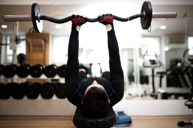 spor salonunda, vücut geliştirmeci triceps ve pazı barbell ile çalışma