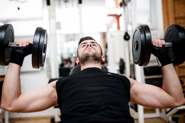 Bodybuilder training in de sportschool: borst - halter bankdrukken — Stockfoto