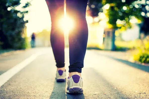 Close-up of woman athlete feet and shoes while running in park. Fitness concept and welfare with female athlete joggin in city park — Stock Photo, Image