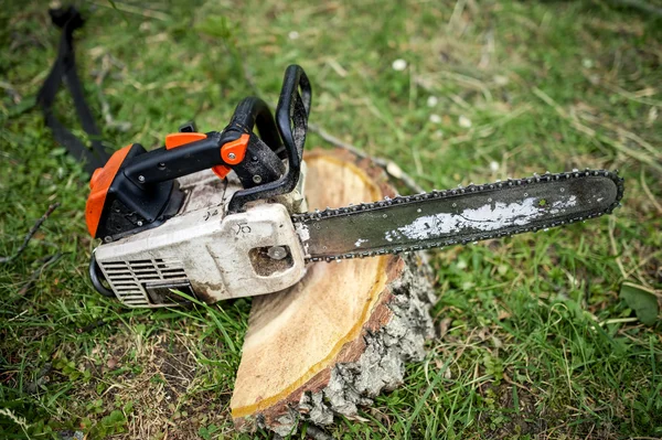 Professionelle Kettensäge auf Stapel von frisch geschnittenem Holz oder Holz — Stockfoto