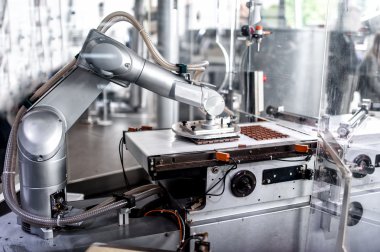 otomatik robot el hareketli ve çikolata çikolata Fabrikası'nda küçücük bit hazırlanıyor. otomatik robot el ile endüstriyel Çikolata Fabrikası