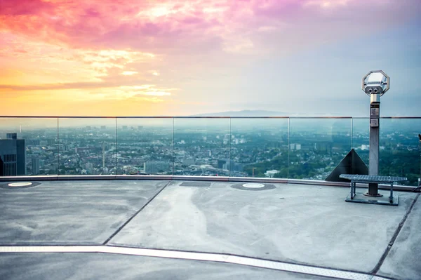 Ferngläser oder Teleskop auf dem Wolkenkratzer auf der Aussichtsplattform, um die Skyline der Stadt bei buntem Sonnenuntergang zu bewundern — Stockfoto