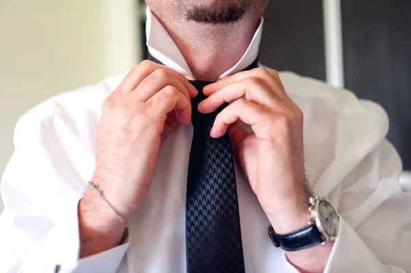 Business man fixing black tie on white shirt. Groom on wedding day fixing tie, vintage effect — Stock Photo, Image