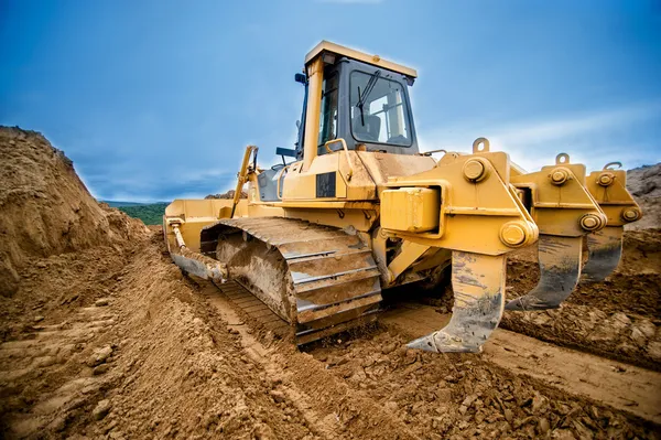 Gros plan du bulldozer ou de la pelle travaillant avec le sol sur l'autoroute — Photo