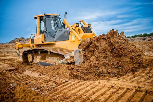 Excavator working with earth and sand in sandpit in highway construction site