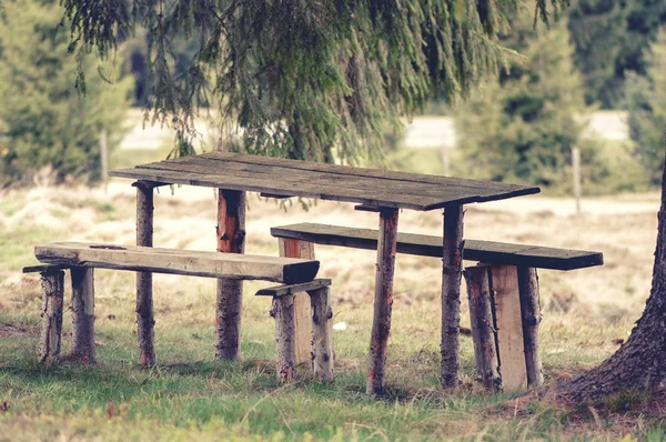 Foto vintage de um banco de madeira, rústico e mesa de piquenique, na floresta — Fotografia de Stock