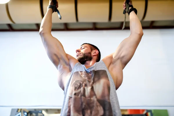 Fisicoculturista haciendo flexiones de mentón, haciendo ejercicio en el gimnasio —  Fotos de Stock