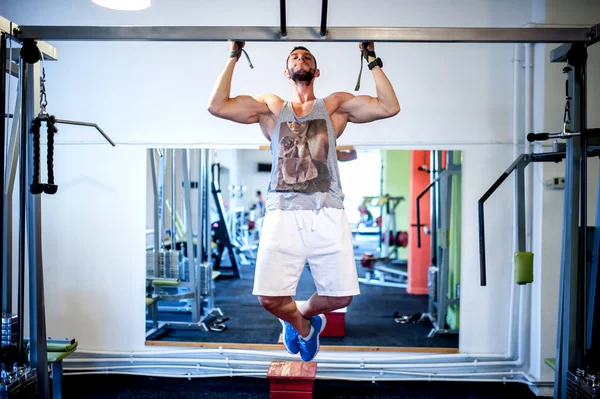 Sexy bodybuilder model working out the back exercises, doing chin ups at the gym — Stock Photo, Image