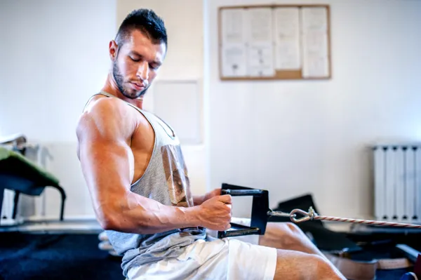 Hombre musculoso en el entrenamiento diario en el gimnasio. Concepto de fitness de una vida saludable —  Fotos de Stock