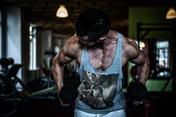 Primer plano del hombre musculoso y atlético haciendo ejercicio en el gimnasio con pesas —  Fotos de Stock