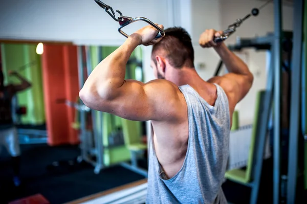 Homem jovem, musculoso, fisiculturista trabalhando no ginásio. Conceito de aptidão na vida saudável, esportes e ginásio — Fotografia de Stock