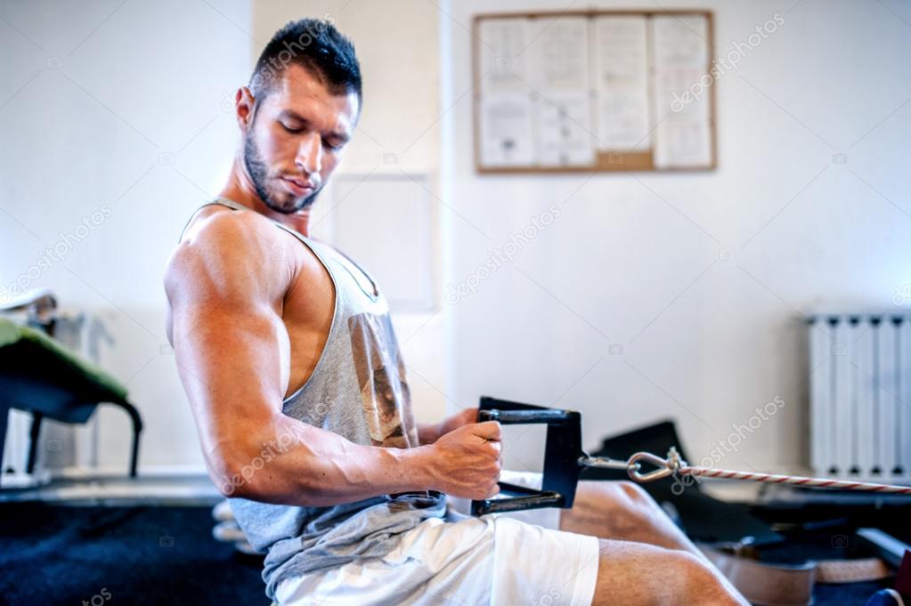 Muscular man on daily workout at gym. Fitness concept of a healthy living