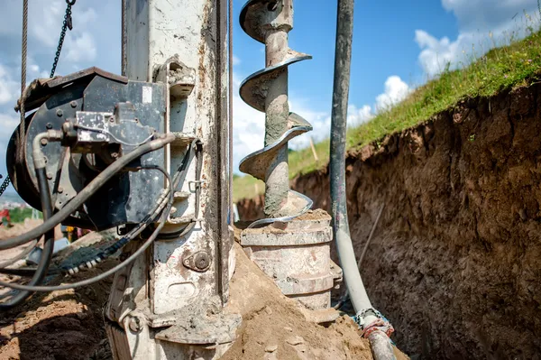 Cierre de barrena, plataforma de perforación industrial haciendo un agujero en el suelo — Foto de Stock