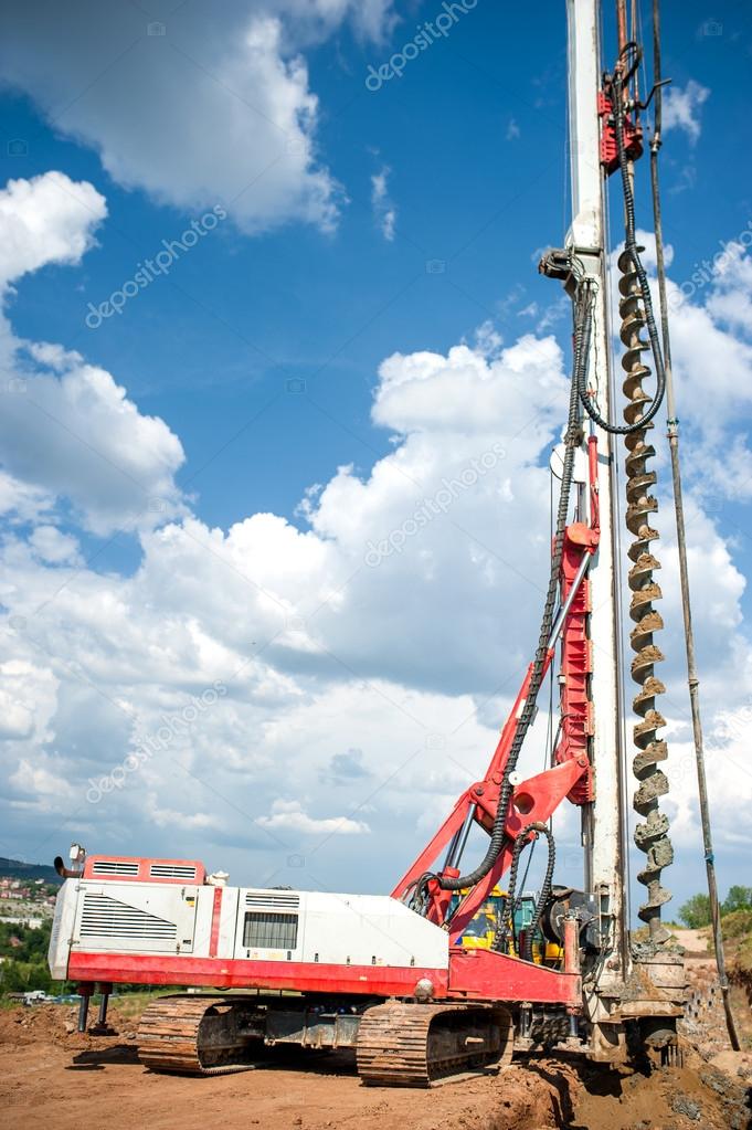 Industrial construction site with drilling rig making holes in the ground