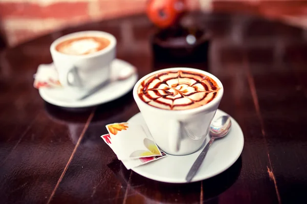 Abstracte vorm op een verse bio koffie in een cup op een houten tafel — Stockfoto