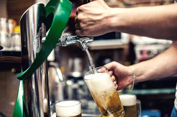 Barkeeper, der im Restaurant, in der Bar oder in der Kneipe ein Bier vom Fass einschenkt oder braut — Stockfoto