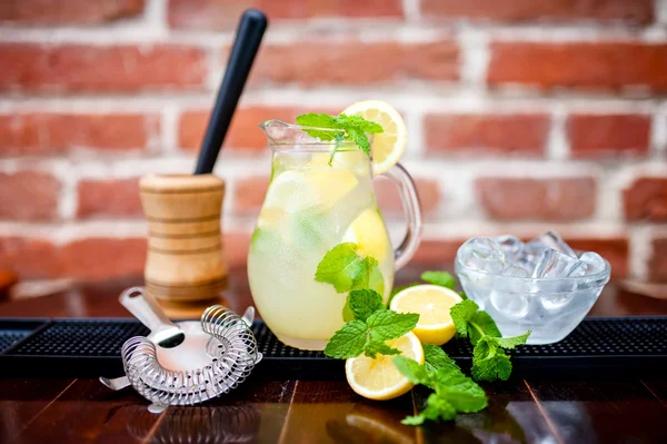 Frische, eisgekühlte Minze-Limonade in einer Kanne mit Zitronenscheiben, Minze und Eis — Stockfoto