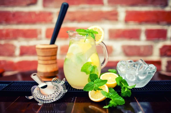 Frische, eisgekühlte Minze-Limonade in einer Kanne mit Zitronenscheiben, Minze und Eis — Stockfoto