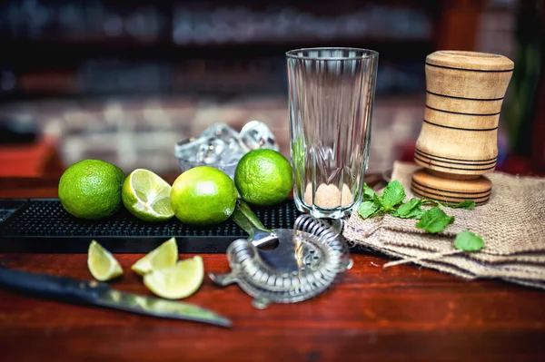 Herstellung von eiskaltem frischem Mojito-Cocktail. leeres Glas und Zutaten auf Theke in Bar — Stockfoto