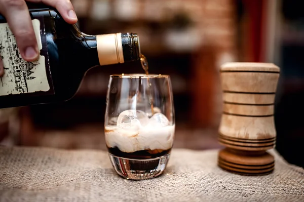 Barman preparando e derramando bebida alcoólica em copo de coquetel — Fotografia de Stock