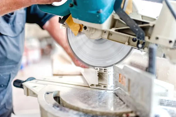 Cutting Window Frame Profile. Circular saw or sliding compound mitre saw cutting window profile. — Stock Photo, Image