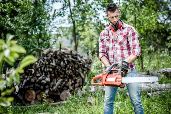 Retrato de hombre agresivo, musculoso y atlético con motosierra preparándose para el corte de leña —  Fotos de Stock