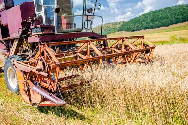 Primer plano de la maquinaria de cosecha de trigo. Actividades agrarias - producción de cultivos con combinación industrial —  Fotos de Stock