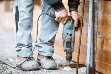 construction worker drill perforate concrete