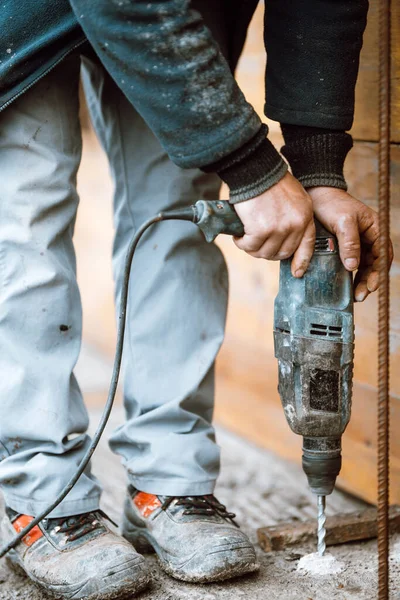 worker on construction site using drilling machine, bricklaying and boring details