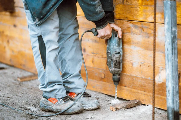 details of construction works - worker on construction site using drilling machine, bricklaying and boring details
