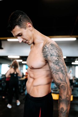 Beden eğitiminde göğüs eğitimi yapan yakışıklı bir adam. Spor eğitmeni ve sporcunun ayrıntıları