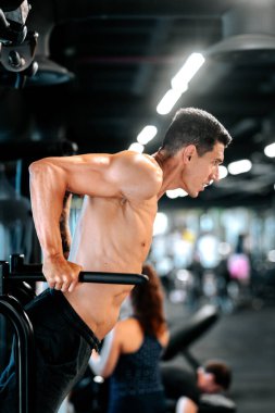 Beyaz adam spor salonunda triseps egzersizi yapıyor.