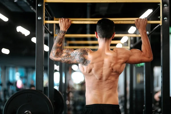 Muskulöser Fitnessmann Der Sich Einer Turnhalle Reck Hochzieht — Stockfoto