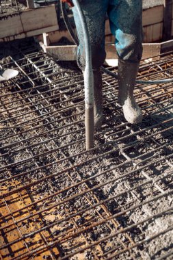 İnşaat işçisi bir ev inşa etmeye çalışıyor. İşçi ve beton vibratör